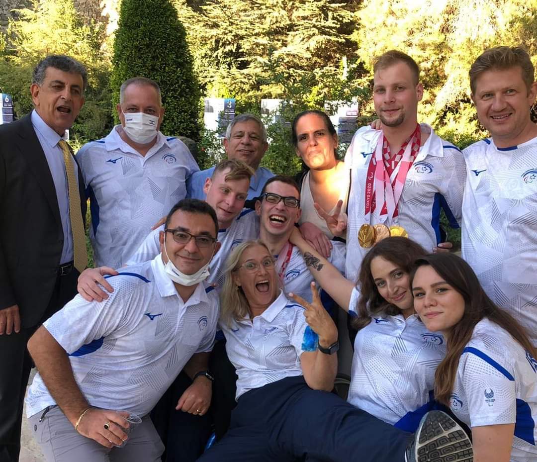 מאמן השחייה יעקב בינינסון שאחראי על 8 מדליות מהמשחקים הפראלימפיים בטוקיו, מתוכם 6 זהב .רואים את מארק מליאר עומד שני משמאל עם שתי מדליות זהב ואת ארד. שתי שחקניות (יושבות בשורה הראשונה מימין) יולה גורדצוק וורוניקה