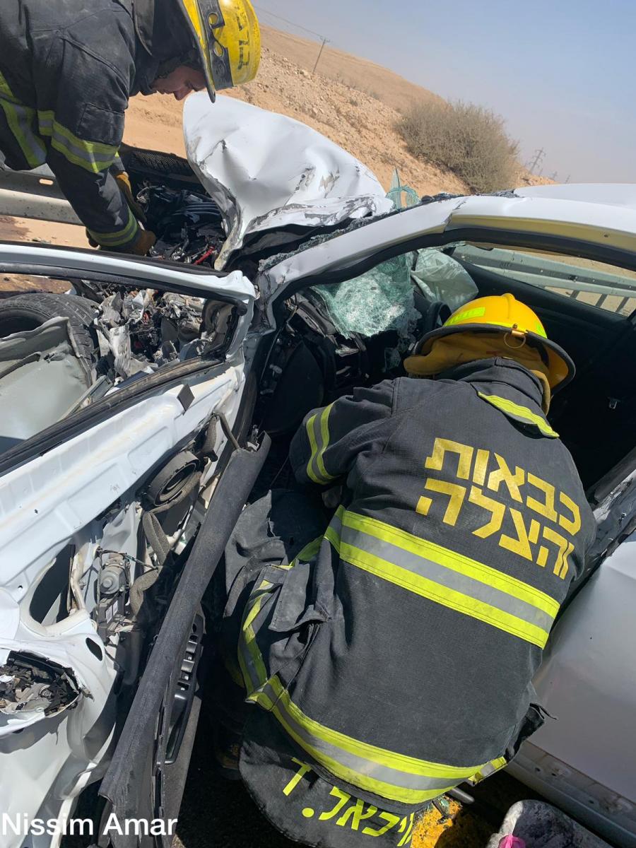 לוחמי אש מתחנת נגב מזרחי מחלצים את הפצוע מהרכב (צילום: נסים עמר / דוברות כיבוי והצלה נגב מזרחי)