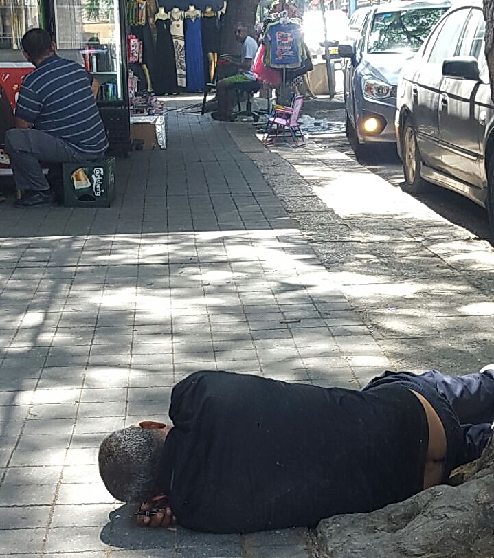 שקוף. אנשים חולפים על פני דר הרחוב ולא שמים לב אפילו