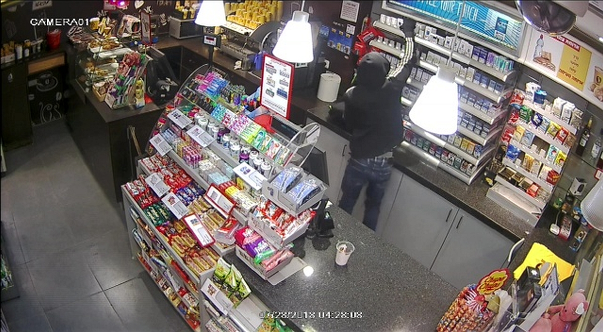 השודד מעמיס סיגריות וטלפונים סלולריים (צילום: מצלמת אבטחה)