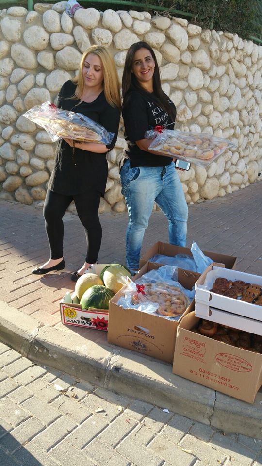 תמיד עם חיוך ותמיד משרה אווירת שמחה: אלינור, מימין, עם חברה, מסייעת ברוחב לב ומכל הנשמה, כאן בדרך להעניק תרומת מזון (צילום: פייסבוק)