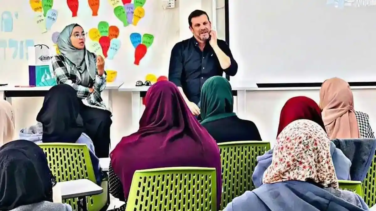 امرأة بدوية شابة تعمل على حاسوب داخل مساحة عمل في النقب