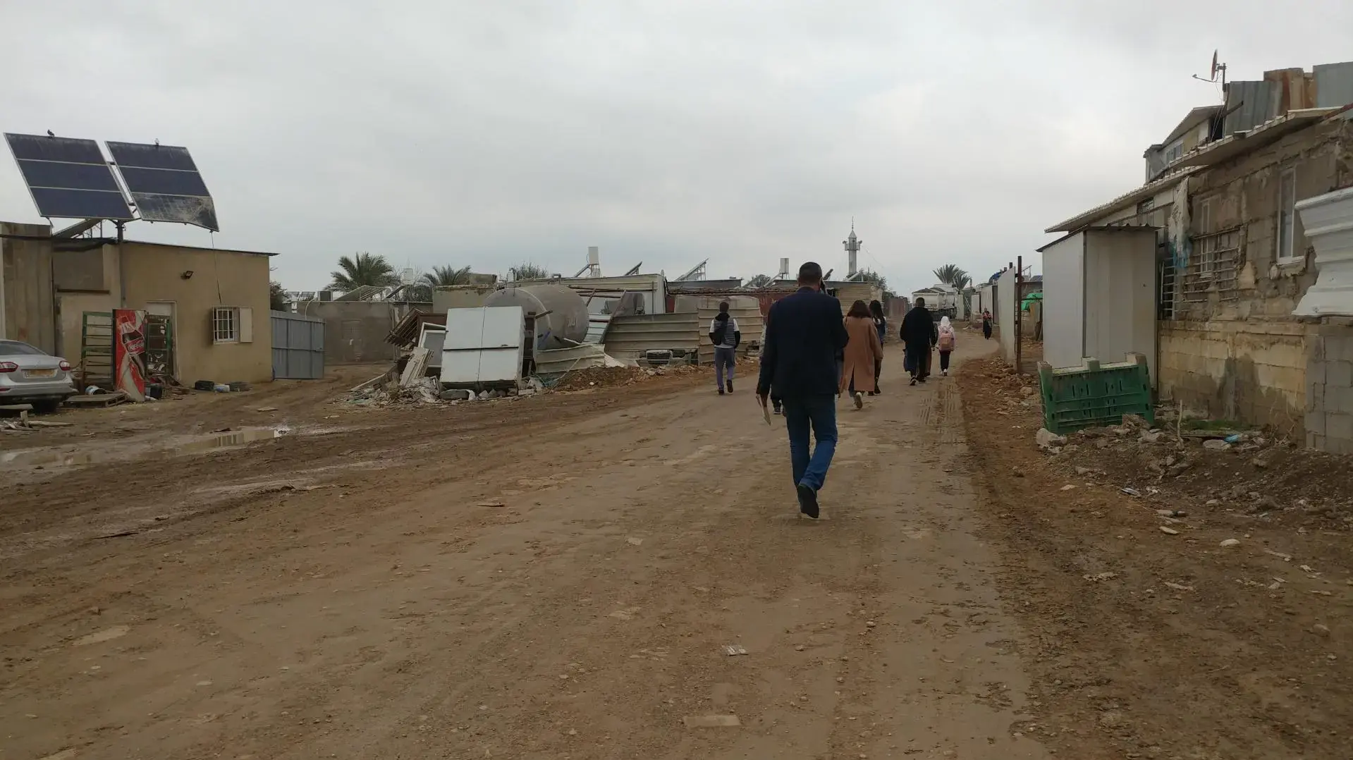 مجموعة شباب بدو يجلسون على مرتفع رملي في النقب ويتأملون الأفق