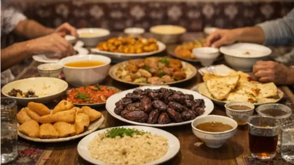 سفرة إفطار عائلية عليها تمر وقهوة وشوربة وخبز وأطباق رئيسية