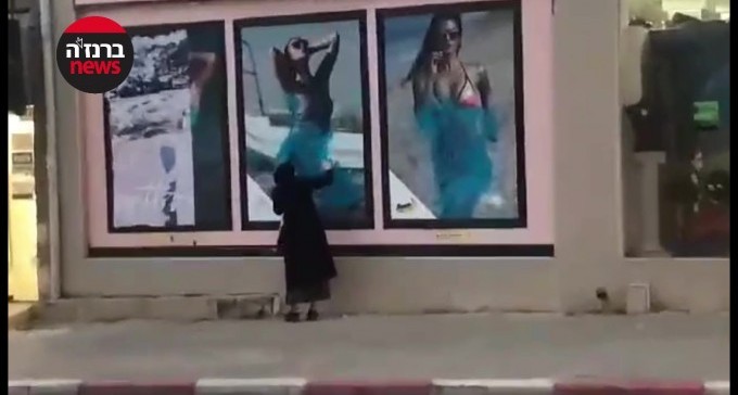 צפו: ריססה בצבע חלון ראווה של חנות בגדים - בגלל צילומי נשים