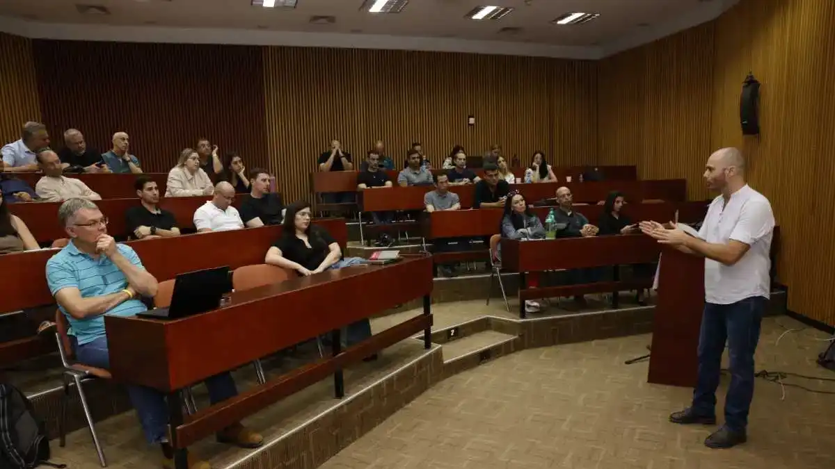 משתתפים בכנס ה-AI הראשון בפארק ההייטק עומר במהלך הרצאה בנושא חדשנות ובינה מלאכותית