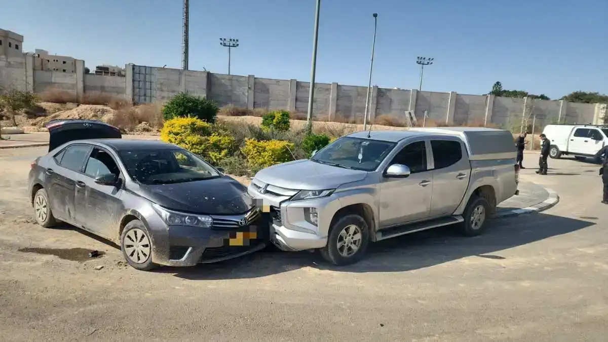 ניידת משטרה עם אורות כחולים דולקים בלילה, כשסביבה זירת מרדף בכביש בנגב.