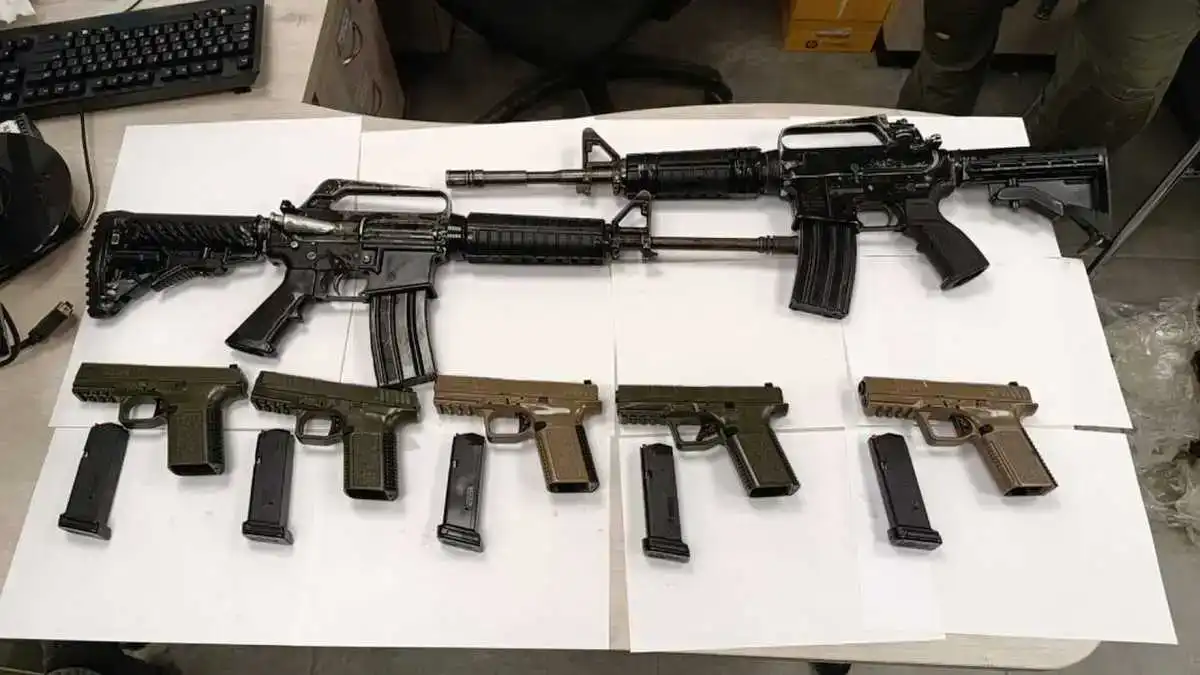 מצבור נשק צבאי שנתפס ליד בסיס בדרום: רובה M16, מחסניות וציוד לחימה מונחים על הקרקע לאחר חשיפה מקרית בידי נער.