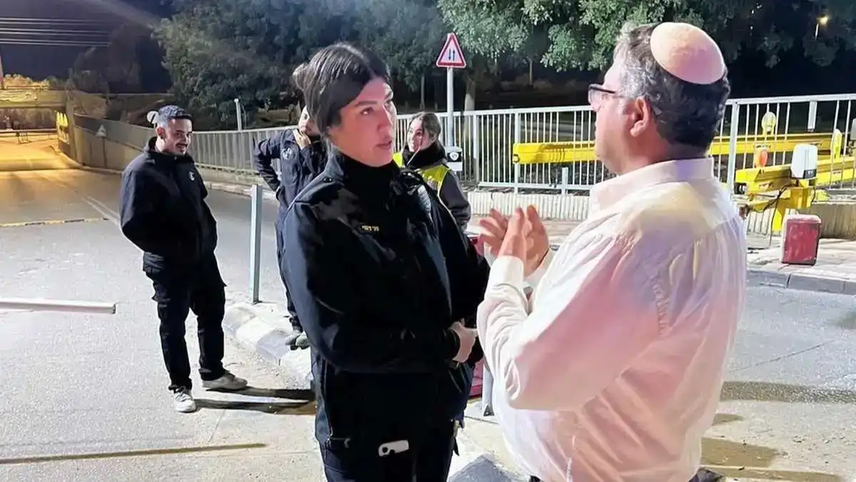 השר איתמר בן גביר עומד לצד כוחות משטרה במהלך סיור לילי בדרום, כשהוא צופה בפריסת הכוחות ובמחסומים במסגרת מבצע 'סדר חדש'.