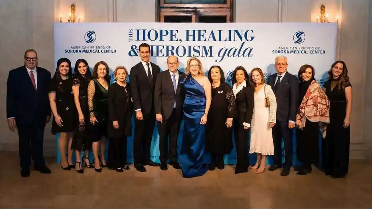 אולם גאלה מעוצב בניו יורק עם עשרות משתתפים היושבים סביב שולחנות, במסגרת אירוע התרמה למען בית החולים סורוקה.