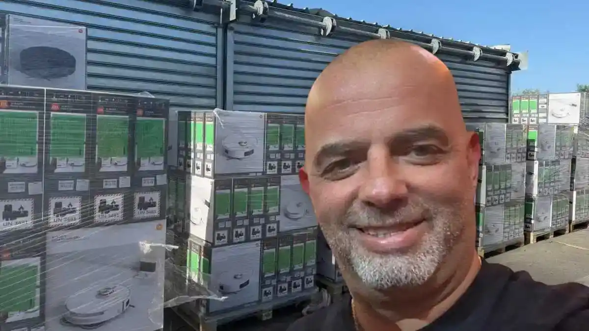 אייל רביד עומד בתוך מחסן עמוס קרטונים של שואבי שיאומי Robot Vacuum S20 Plus, לפני תחילת מכירתם ברשת ויקטורי במחיר מוזל