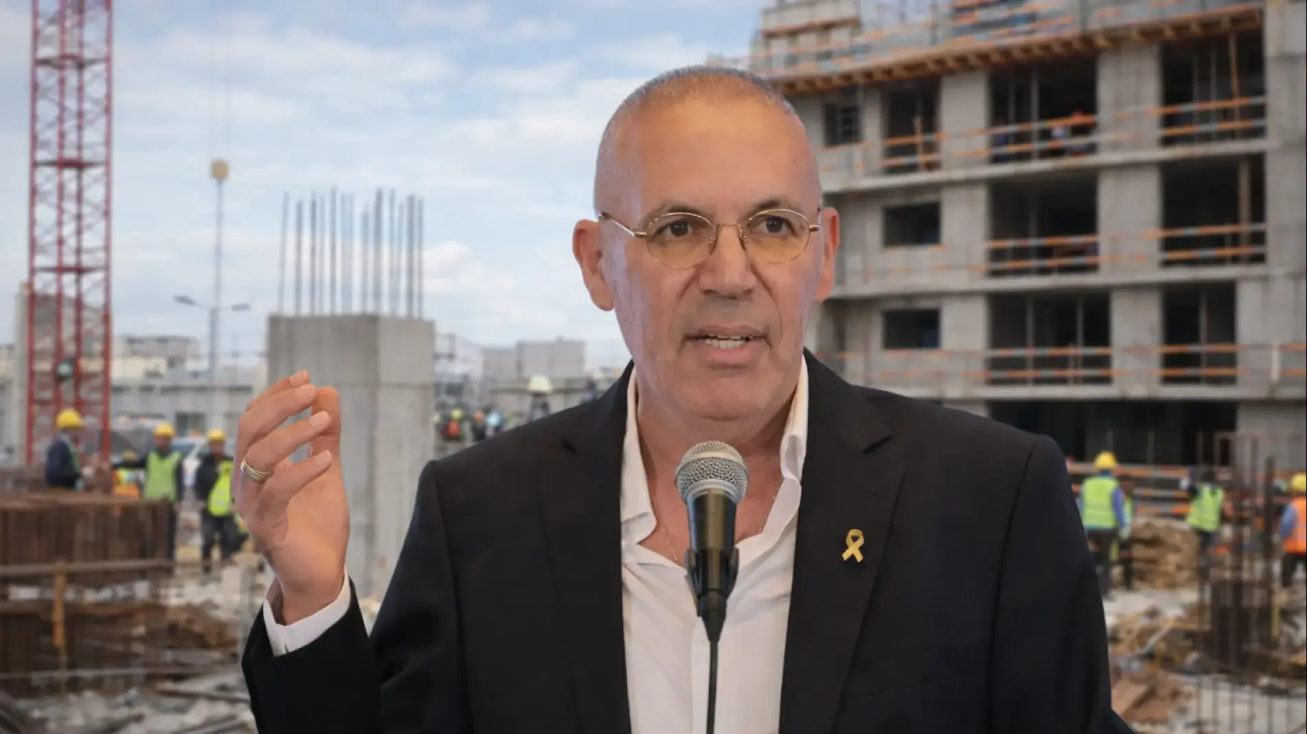 אלי אביסרור על רקע אתר בניה