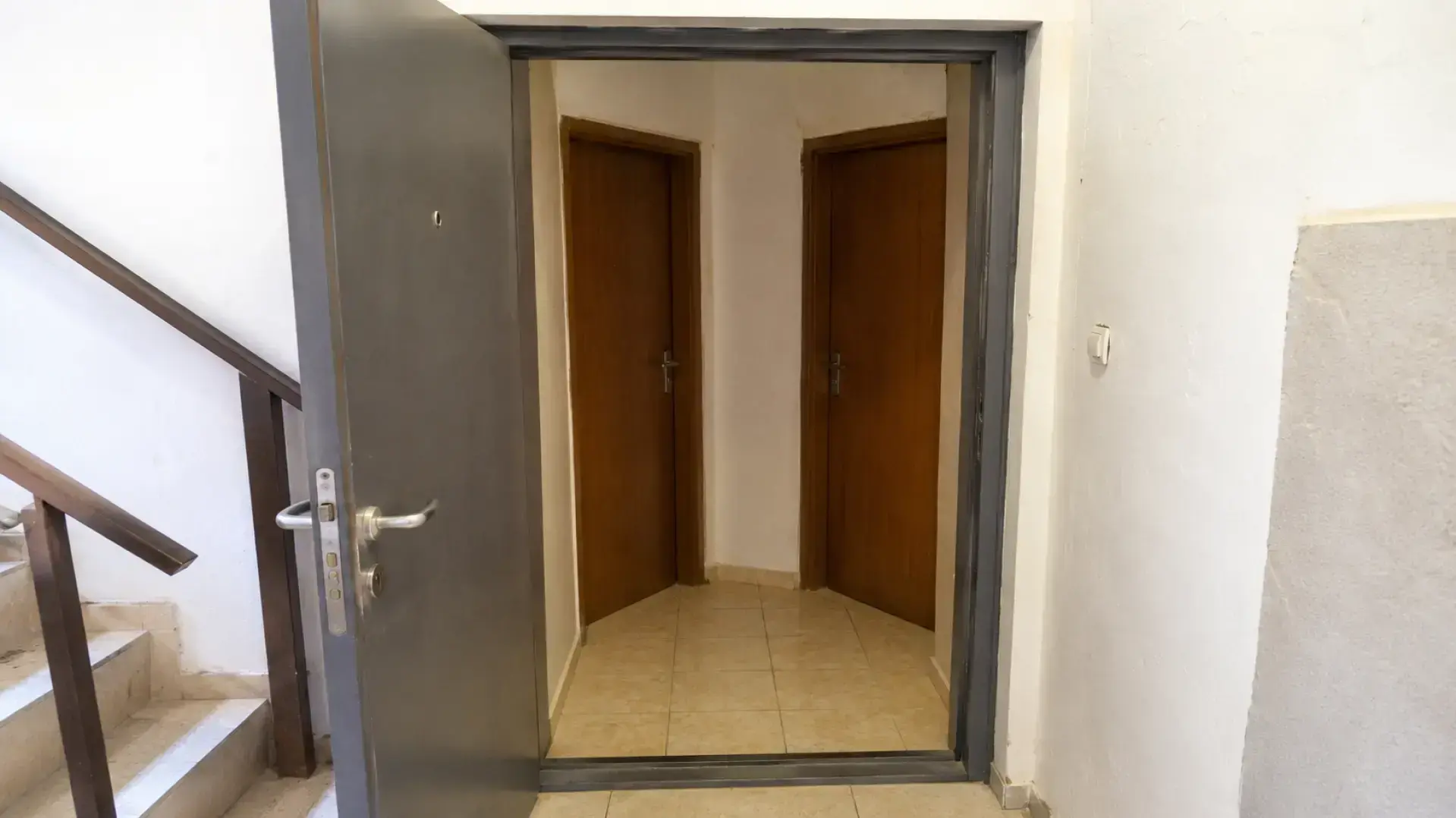 דירה שחולקה למספר יחידות בתוך בניין ותיק בבאר שבע לצד לוח חשמל ותשתיות משותפות