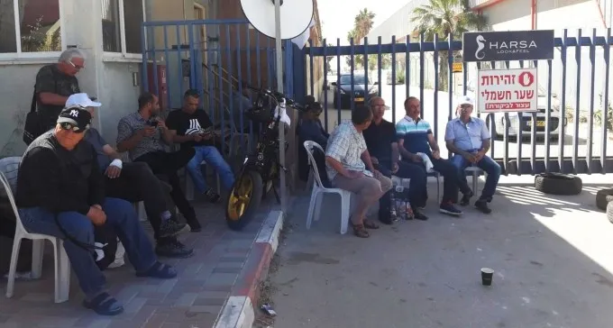 גם תחת איום טילים, מפוטרי חרסה ממשיכים לשבת בכניסה למפעל הנעול