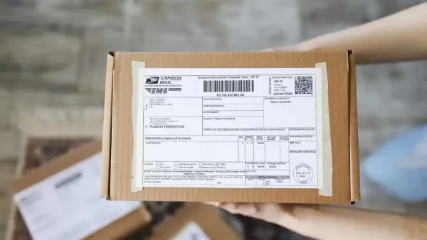 צילום של חבילות דואר נערמות בנקודת חלוקה בישראל, עם צרכנים הממתינים לקבלת משלוחים מחו