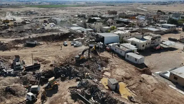 כוחות רמ״י ויחידת יואב מבצעים פינוי סוללות עפר ושטחים שנפלשו ביישוב לקיה, כלי עבודה ומשאיות בשטח.