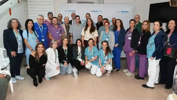 חן ויובל לאחר החתונה מבקרים בסורוקה ומחייכים לצד הצוות הרפואי שטיפל בו במהלך השיקום.