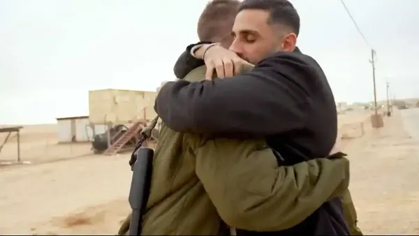 שגב כלפון עם לוחמי בא״ח נח״ל בנר האחרון של חנוכה במהלך חלוקת סופגניות בבסיס