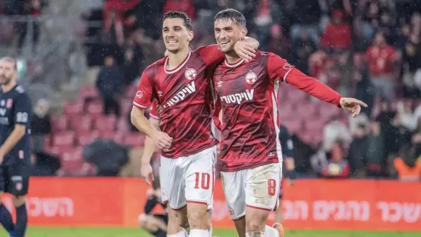 אצטדיון טרנר בבאר שבע בשעת ערב במהלך משחק גביע, יציעים אדומים ואווירת משחק