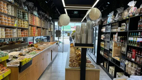 חנות המפעל של “אלוף הפיצוחים” בעמק שרה בבאר שבע עם מדפי פיצוחים ופירות יבשים ומיתוג התוכי הירוק