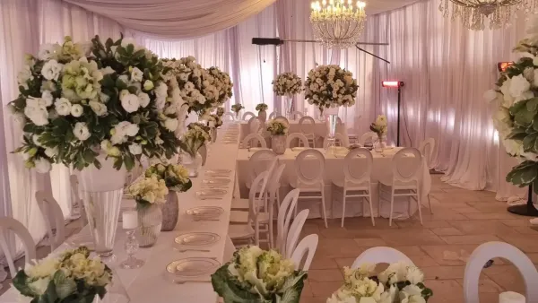 הרב עדי אהרונוב מארח בחצר ביתו שבת קהילתית בשכונת כלניות, עם אוהל אירוח גדול ושולחנות ערוכים לשכנים