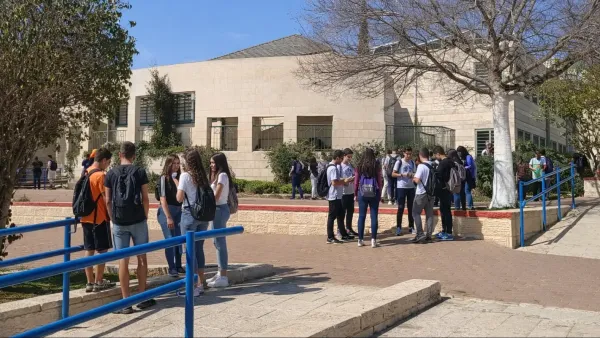 תלמידי תיכון בבאר שבע מחוץ לבית ספר ביום בגרות, על רקע כיתות ומבני העיר, אווירת מאמץ והכרעה