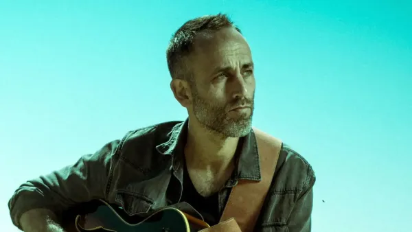 איתי פרל מופיע בחלל התצוגה של מוזיאון הנגב לאמנות במסגרת סדרת משמרת לילה מול קהל יושב באווירה אינטימית