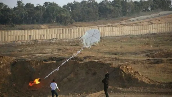 עפיפון סמוך לגבול רצועת עזה על רקע שדות עוטף עזה וכוחות ביטחון באזור`