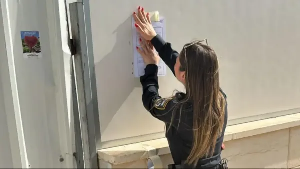 שוטר מדביק צו סגירה מנהלי באתר בנייה ביישוב עומר לאחר איתור שוהים בלתי חוקיים.