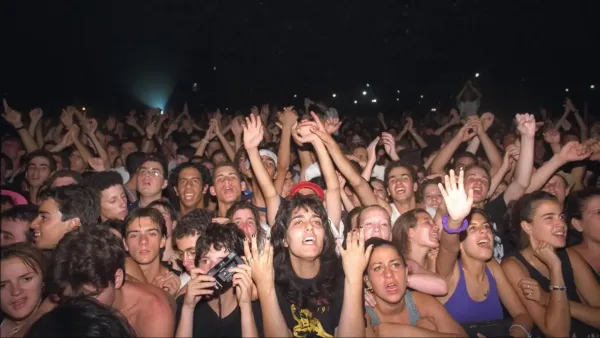 קהל בפסטיבל מוזיקה בערד בשעות הערב, עם במת הופעות גדולה ואווירת חגיגה במדבר.