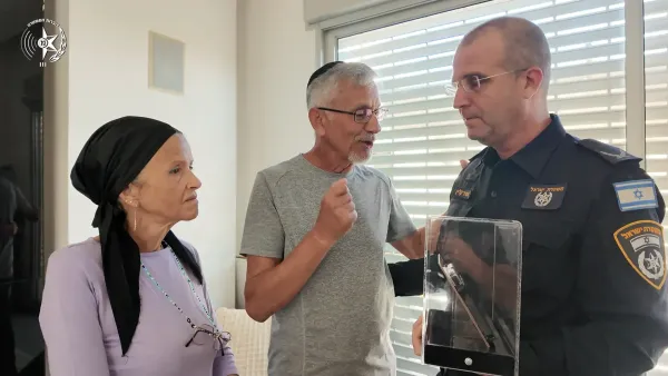 מפקד מרחב נגב תנ'צ אמיר קליין מעניק למשפחת רנ'ג איתמר אלוס ז'ל את נשקו האישי וכרית ההנצחה.