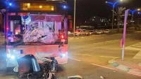 אוטובוס עירוני בזירת תאונת דרכים עם קטנוע פגוע, לאחר התנגשות קטלנית בערד, כשכוחות חירום פועלים במקום