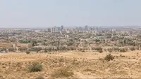 אנשים מתמודדים עם מזג אוויר שרבי וחם ברחובות ישראל.