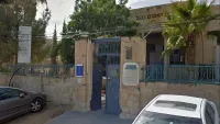 בית האמנים בבאר שבע על רקע ספרים בעברית ובערבית, המסמל את סערת ביטול יריד הספרים העברי-ערבי בעיר.