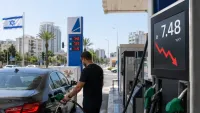 נהג מתדלק רכב בתחנת דלק בישראל לצד מחיר חדש של 7.48 שקלים לליטר