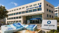 טלפון נייד עם הודעת הפקדה מביטוח לאומי לצד שטרות כסף
